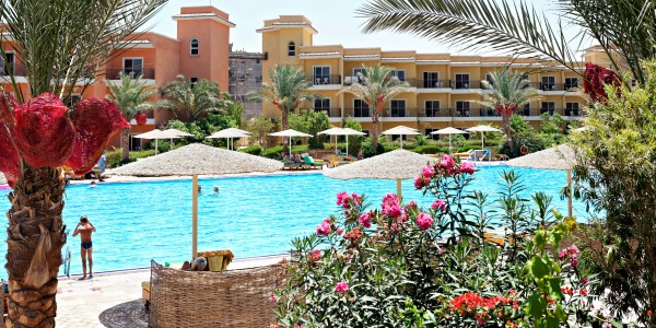 Hotel met kleurrijke gebouwen, tropische bloemen en een helderblauw zwembad