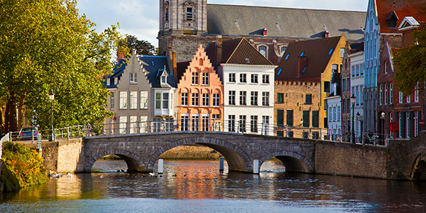 stadskanaal met brug langs gekleurde herenhuizen in gent, belgie